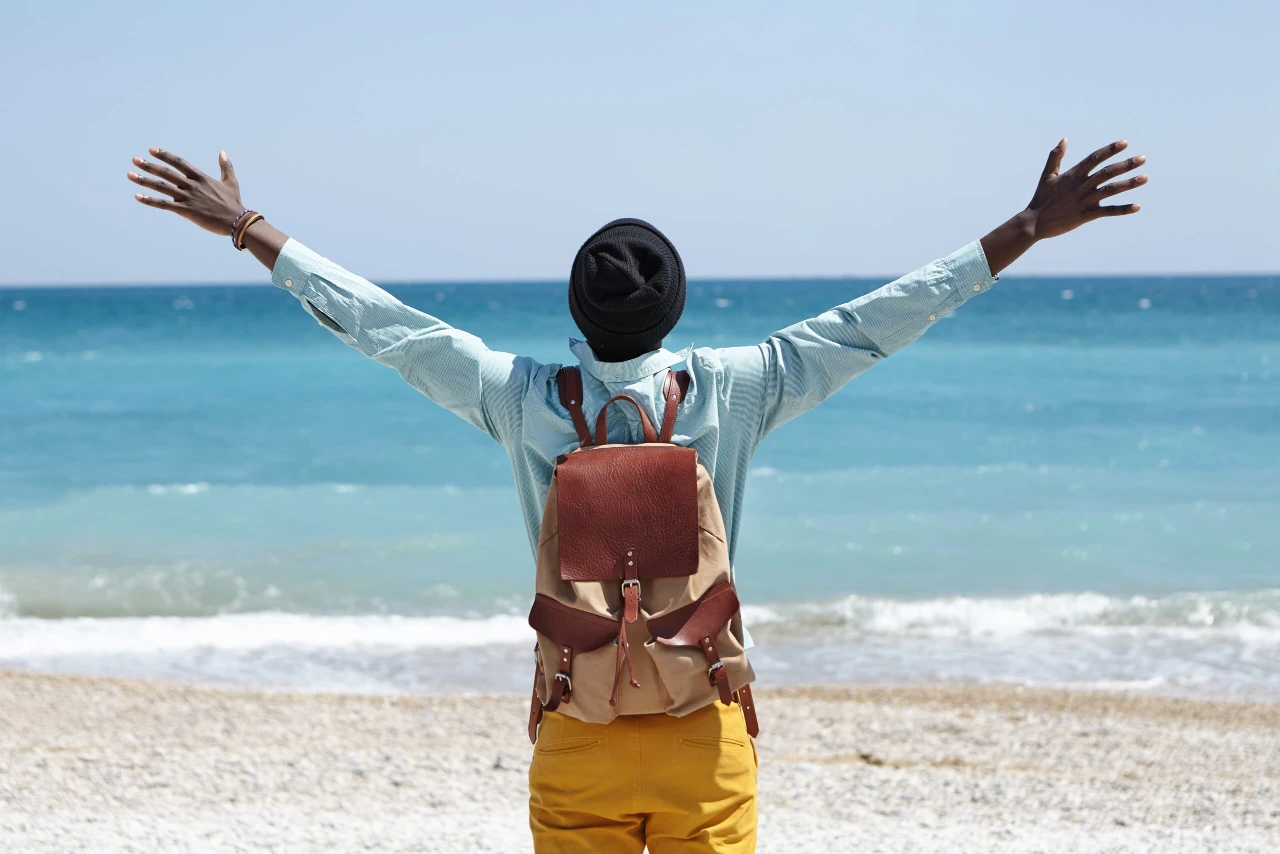 read-view-happy-carefree-african-american-male-standing-beach-front-azure-sea-spreading-arms-feeling-freedom-connection-amazing-nature-around-him-scaled