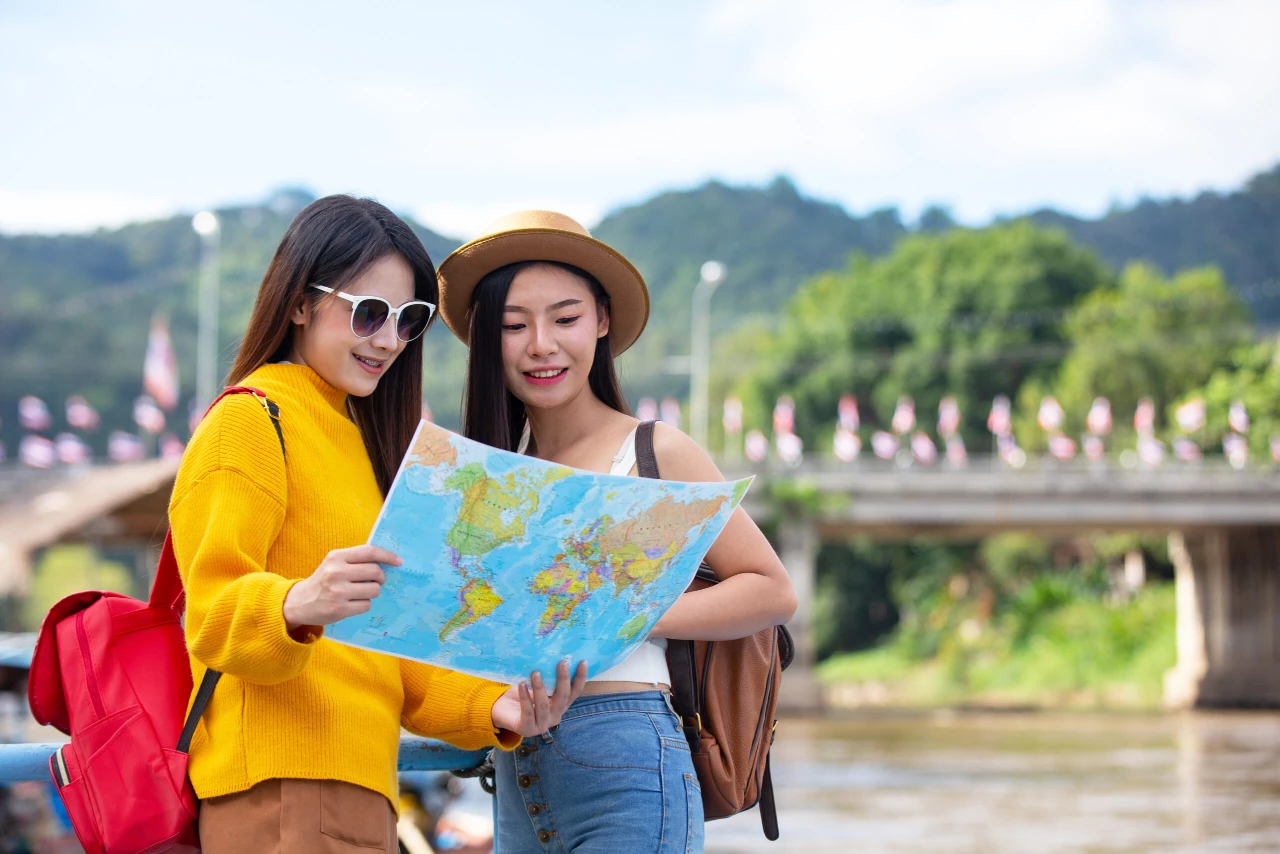 two female tourists hold map find places